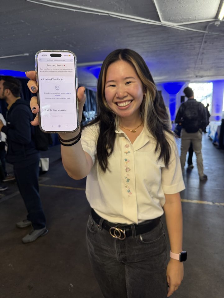 Priscilla holding up the Postcard Press prototype on her phone at ProductCon